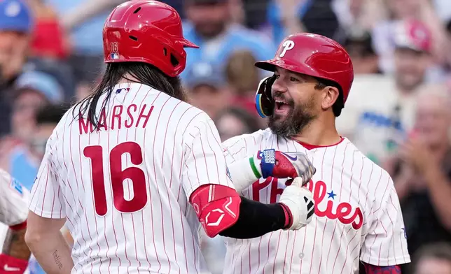 Philadelphia Phillies' Brandon Marsh, left, and Kyle Schwarber celebrate after Marsh's home run against Miami Marlins pitcher Tyler Phillips during the second inning of a baseball game Tuesday, June 16, 2026, in Philadelphia. (AP Photo/Matt Slocum)