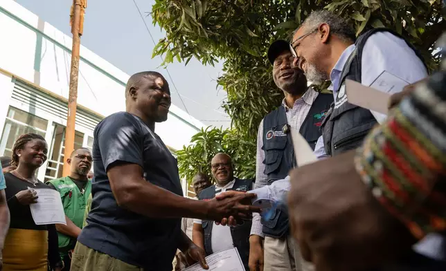Director General of the World Health Organisation (WHO), Tedros Adhanom Ghebreyesus, right, shakes hands with Ezo Etienne, a health worker who recovered from Ebola in Bunia, Congo, Sunday, May 31, 2026. (AP Photo/Moses Sawasawa)