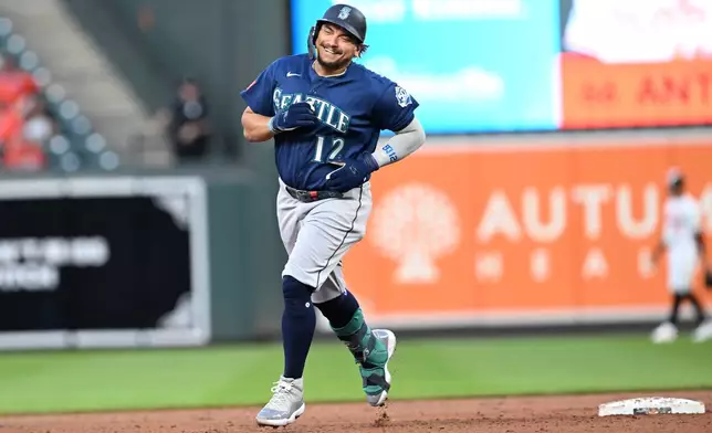 Seattle Mariners' Josh Naylor (12) smiles as he rounds second base after hitting a grand slam against the Baltimore Orioles in the fifth inning of a baseball game, Monday, June 8, 2026, in Baltimore. (AP Photo/Gail Burton)