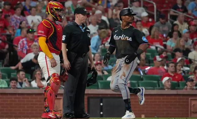Miami Marlins' Esteury Ruiz, right, scores past St. Louis Cardinals catcher Iván Herrera, left, during the eighth inning of a baseball game Friday, June 26, 2026, in St. Louis. (AP Photo/Jeff Roberson)