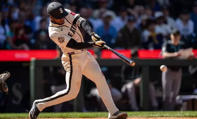 Seattle Mariners' Victor Robles hits an RBI single during the 10th inning of a baseball game against the Arizona Diamondbacks, Sunday, May 31, 2026, in Seattle. (AP Photo/Stephen Brashear)