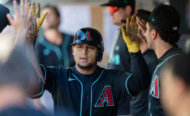 Arizona Diamondbacks' Gabriel Moreno is congratulated by teammates in the dugout after scoring a run during the eighth inning of a baseball game against the Seattle Mariners, Sunday, May 31, 2026, in Seattle. (AP Photo/Stephen Brashear)