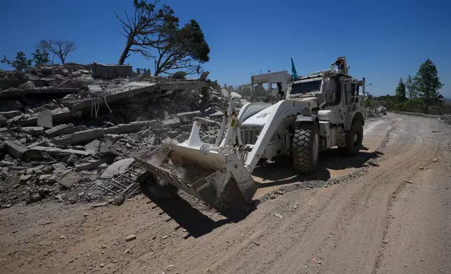 A bulldozer for the Spanish U.N peacekeeper opens a road in front of a house that was destroyed in the recent clashes between Hezbollah fighters and Israeli troops in Dibbine village, southeast Lebanon, Friday, June 5, 2026, a day after Israeli forces withdrew. (AP Photo/Hussein Malla)