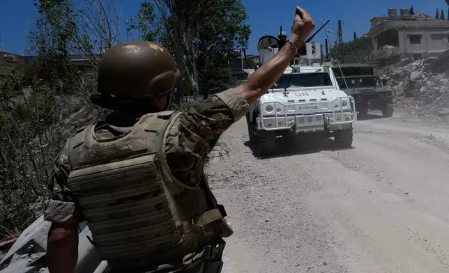 A Lebanese soldier gestures in front of a Spanish U.N peacekeeper vehicle Dibbine village, southeast Lebanon, Friday, June 5, 2026, a day after Israeli forces withdrew following clashes with Hezbollah fighters. (AP Photo/Hussein Malla)
