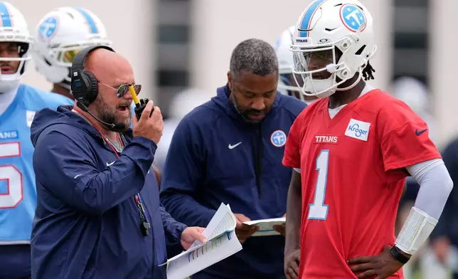 Tennessee Titans offensive coordinator Brian Daboll, right, uses a radio with quarterback Cam Ward (1) during an NFL football practice Tuesday, June 9, 2026, in Nashville, Tenn. (AP Photo/George Walker IV)