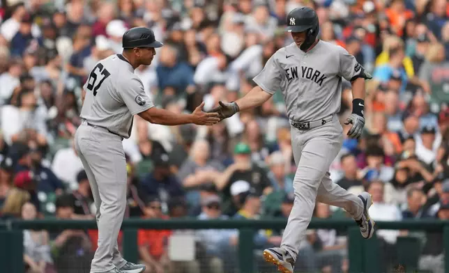 New York Yankees' Paul Goldschmidt is congratulated by third base coach Luis Rojas after hitting a home run against the Detroit Tigers during the third inning of a baseball game Wednesday, June 24, 2026, in Detroit. (AP Photo/Paul Sancya)