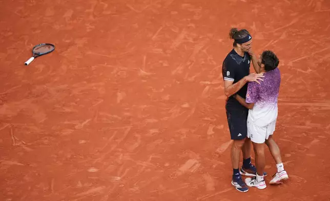 Winner Alexander Zverev of Germany, left, and second placed Flavio Cobolli of Italy hug after their men's final match at the French Open tennis tournament in Paris, Sunday, June 7, 2026. (AP Photo/Aurelien Morissard)