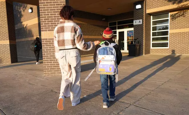 Maria Contreras, left, walks her son, Ian Contreras, to school Thursday, April 9, 2026, in Fort Worth, Texas. (AP Photo/Julio Cortez)