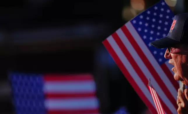 A person watches the stage before President Donald Trump speaks at the opening of the Great American State Fair on the National Mall, Wednesday, June 24, 2026, in Washington. (AP Photo/Julia Demaree Nikhinson)