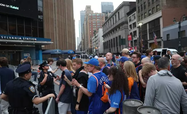 Fans wait to pass police on Eighth Avenue outside of Madison Square Garden ahead of Game 4 of the NBA Finals between the New York Knicks and San Antonio Spurs, Wednesday, June 10, 2026, in New York. (AP Photo/Heather Khalifa)