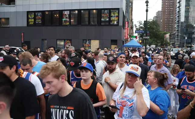 Fans wait to pass police on Eighth Avenue outside of Madison Square Garden ahead of Game 4 of the NBA Finals between the New York Knicks and San Antonio Spurs, Wednesday, June 10, 2026, in New York. (AP Photo/Heather Khalifa)