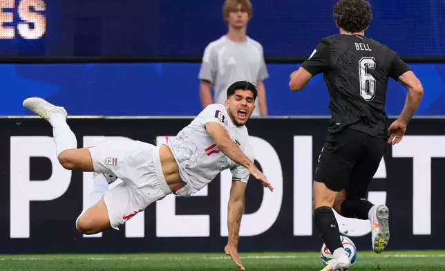 Iran's Arya Yousefi (17) and New Zealand's Joe Bell (6) battle for the ball during the World Cup Group G soccer match between Iran and New Zealand in Inglewood, Calif., near Los Angeles, Monday, June 15, 2026. (AP Photo/Mark J. Terrill)