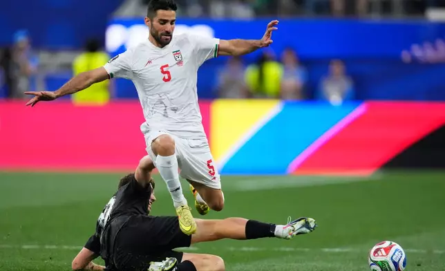 Iran's Milad Mohammadi (5) jumps over New Zealand's Callum McCowatt (20) during the World Cup Group G soccer match between Iran and New Zealand in Inglewood, Calif., near Los Angeles, Monday, June 15, 2026. (AP Photo/Mark J. Terrill)