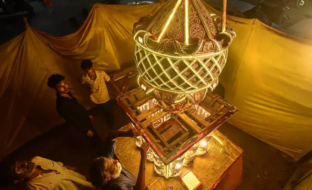 Artisans from Pakistani Hindu community, give final touches to a replica of the mausoleum of Imam Hussain locally called 'Tazia', in preparation for the upcoming Ashoura, when Shiites Muslims mark the death of Hussein, at their home in Karachi, Pakistan, Tuesday, June 23, 2026. (AP Photo/Ali Raza)