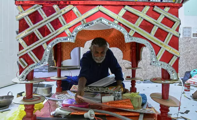 Raju Rathore, an artisan from Pakistani Hindu community, makes a replica of the mausoleum of Imam Hussain locally called 'Tazia', in preparation for the upcoming Ashoura, when Shiites Muslims mark the death of Hussein, at his home in Karachi, Pakistan, Tuesday, June 23, 2026. (AP Photo/Ali Raza)