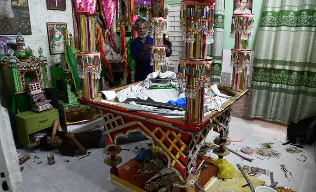 Raju Rathore, an artisan from Pakistani Hindu community, makes a replica of the mausoleum of Imam Hussain locally called 'Tazia', in preparation for the upcoming Ashoura, when Shiites Muslims mark the death of Hussein, at his home in Karachi, Pakistan, Tuesday, June 23, 2026. (AP Photo/Ali Raza)