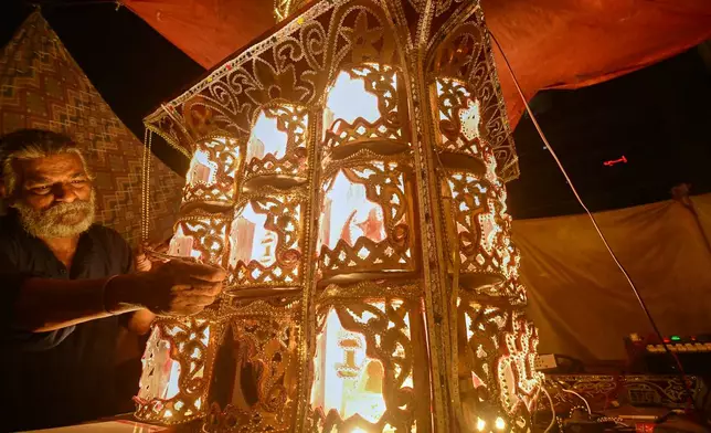 Raju Rathore, an artisan from Pakistani Hindu community, gives final touches to a replica of the mausoleum of Imam Hussain locally called 'Tazia', in preparation for the upcoming Ashoura, when Shiites Muslims mark the death of Hussein, at his home in Karachi, Pakistan, Tuesday, June 23, 2026. (AP Photo/Ali Raza)