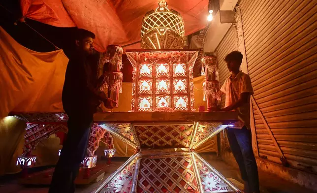 Artisans from Pakistani Hindu community, give final touches to a replica of the mausoleum of Imam Hussain locally called 'Tazia', in preparation for the upcoming Ashoura, when Shiites Muslims mark the death of Hussein, at their home in Karachi, Pakistan, Tuesday, June 23, 2026. (AP Photo/Ali Raza)