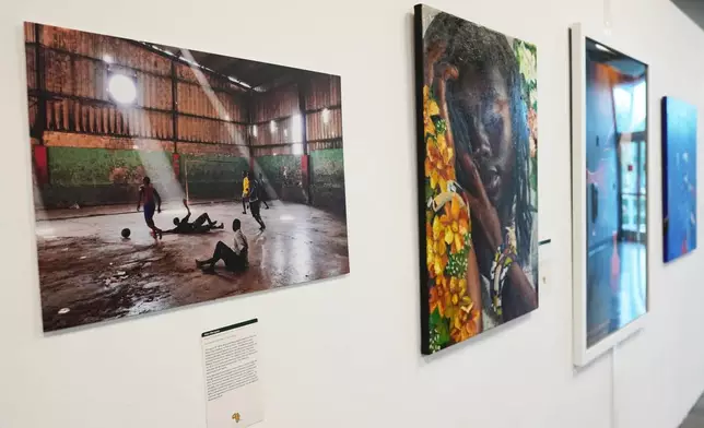 A photograph titled, "Boulos Warehouse," by photographer Alan Marques showing soccer players playing in a warehouse in Haiti is displayed in an exhibition, "Art and the Beautiful Game: Africa on the World Stage," on May 30, 2026, in North Miami, Fla. (AP Photo/Lynne Sladky)