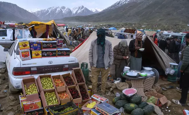 Spectators eat food from a makeshift food stall at a temporary tent village set up for three-day annual Shandur Polo Festival in Shandur Pass, in the Ghizer district of Gilgit-Baltistan, northern Pakistan, Friday, June 12, 2026. (AP Photo/Zubair Abbasi)