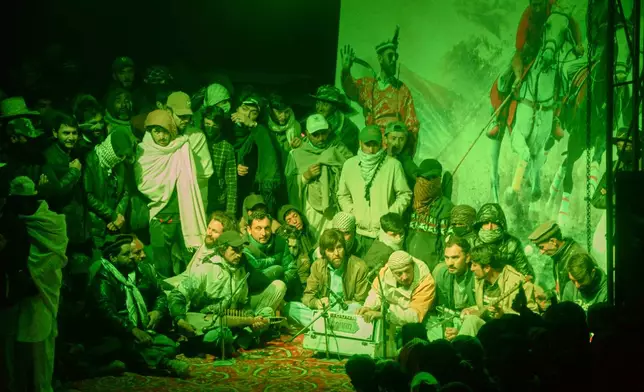 Spectators listen to a folk music performance at a temporary tent village set up for three-day annual Shandur Polo Festival in Shandur Pass, in the Ghizer district of Gilgit-Baltistan, northern Pakistan, Thursday, June 11, 2026. (AP Photo/Zubair Abbasi)