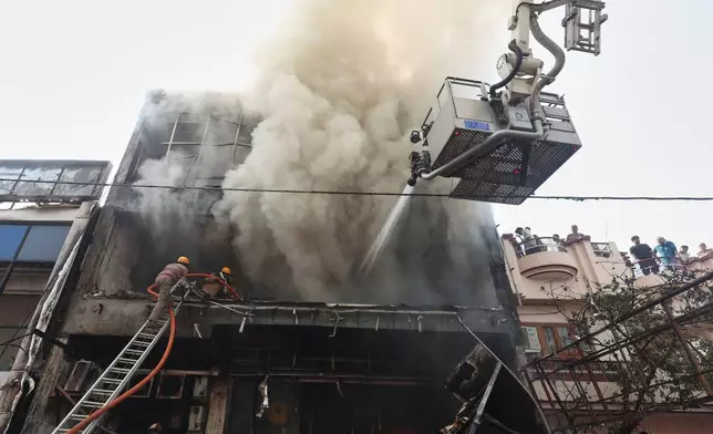 Firefighters work to put out a fire in a commercial building in Lucknow, India, Monday, June 22, 2026. (AP Photo/Sumit Kumar)