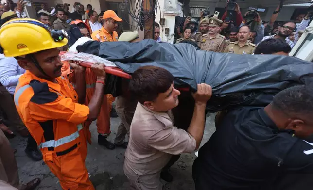 Rescue workers carry a victim on a stretcher after a fire broke out at a coaching centre in Lucknow, India, Monday, June 22, 2026. (AP Photo/Sumit Kumar)