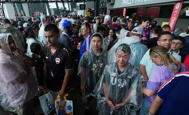 Fans wait in a sheltered area of the stadium as bad weather halts play during the World Cup Group I soccer match between France and Iraq in Philadelphia, Monday, June 22, 2026. (AP Photo/Matt Rourke)