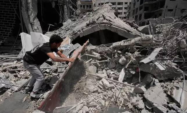 A man removes debris of a building that was hit Monday in an Israeli airstrike in the southern port city of Tyre, Lebanon, Tuesday, June 2, 2026. (AP Photo/Mohammed Zaatari)