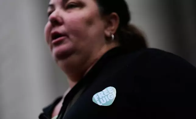 A woman wearing a "Free Luigi" pin talks to reporters outside a federal courthouse in New York, Monday, June 29, 2026. (AP Photo/Seth Wenig)