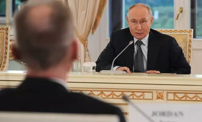 Russian President Vladimir Putin, foreground answers to a question by The Associated Press News Director of Europe/Africa James Jordan, back to a camera as he meets with representatives of international news agencies on the sidelines of the St. Petersburg International Economic Forum at the Constantine Palace in St. Petersburg, Russia, on Thursday, June 4, 2026. (AP Photo/Dmitri Lovetsky, Pool)