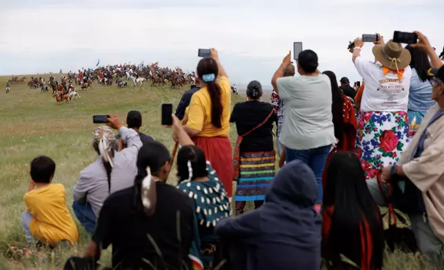 Spectators watch the charging event during festivities to commemorate the 150th anniversary of the Battle of the Little Bighorn in Crow Agency, Mont., on Thursday, June 25, 2026. (AP Photo/Tailyr Irvine)