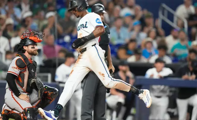 Miami Marlins' Esteury Ruiz scores on a single hit by Jakob Marsee during the fourth inning of a baseball game against the San Francisco Giants, Saturday, June 20, 2026, in Miami. (AP Photo/Lynne Sladky)