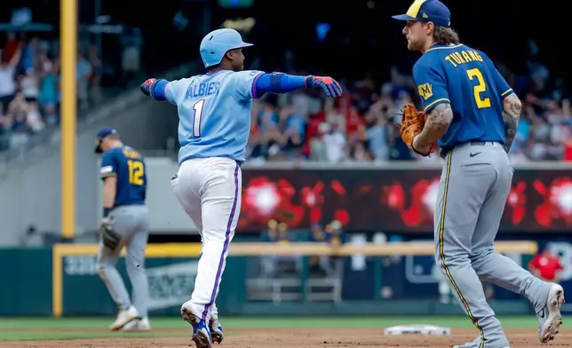 Atlanta Braves' Ozzie Albies, left, celebrates in front of Milwaukee Brewers second baseman Brice Turang, right, after hitting a game-winning two-run home run against the Milwaukee Brewers during the ninth inning of a baseball game, Saturday, June 20, 2026, in Atlanta. (AP Photo/Erik S. Lesser)