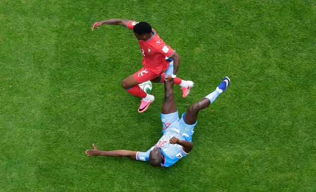 Congo's Yoane Wissa (20) lies on his back asPortugal's Nelson Semedo (2) tres to run around him during the World Cup Group K soccer match between Portugal and Congo in Houston, Wednesday, June 17, 2026. (AP Photo/Michael Wyke)