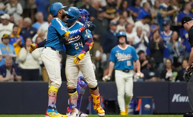 Milwaukee Brewers' William Contreras (24) hugs Milwaukee Brewers' Jackson Chourio, left, after hitting a two-run home run during the seventh inning of a baseball game against the Chicago Cubs, Friday, June 26, 2026, in Milwaukee. (AP Photo/Aaron Gash)