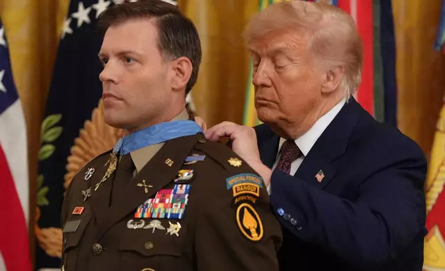 President Donald Trump, right, awards the Medal of Honor to retired Army Maj. Nicholas Dockery, in the East Room of the White House, Thursday, June 18, 2026, in Washington. (AP Photo/Jacquelyn Martin)