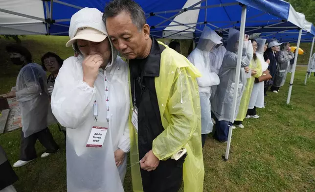 Ashley E. Terrell, left, a Korean adoptee from the United States and Christian Jang-Mikkelsen, a Korean adoptee from Denmark, embrace after hanging their nametags at The Wall of Names at Omma Poom Park in Paju, South Korea, on May 20, 2026. (AP Photo/Ahn Young-joon)
