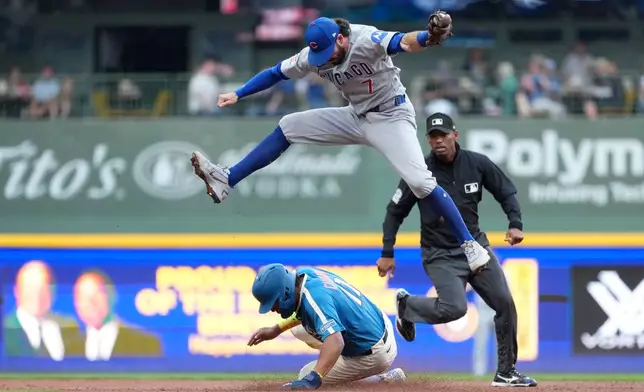 Milwaukee Brewers' Jackson Chourio, bottom, steals second base as Chicago Cubs' Dansby Swanson (7) leaps to catch the ball during the third inning of a baseball game Saturday, June 27, 2026, in Milwaukee. (AP Photo/Aaron Gash)