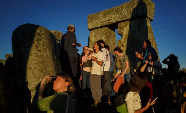 Revelers gather at the ancient stone circle Stonehenge to celebrate the summer solstice, the longest day of the year, near Salisbury, England, on Saturday, June 20, 2026. (AP Photo/Alberto Pezzali)