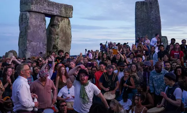 Revelers gather at the ancient stone circle Stonehenge to celebrate the summer solstice, the longest day of the year, near Salisbury, England, on Saturday, June 20, 2026. (AP Photo/Alberto Pezzali)