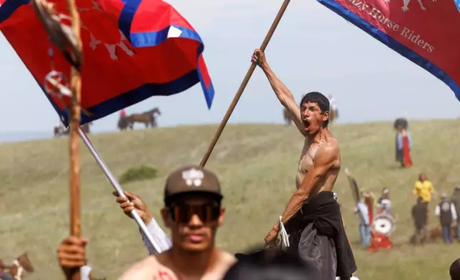 Riders celebrate the horse charge event during festivities to commemorate the 150th anniversary of the Battle of the Little Bighorn in Crow Agency, Mont., on Thursday, June 25, 2026. (AP Photo/Tailyr Irvine)