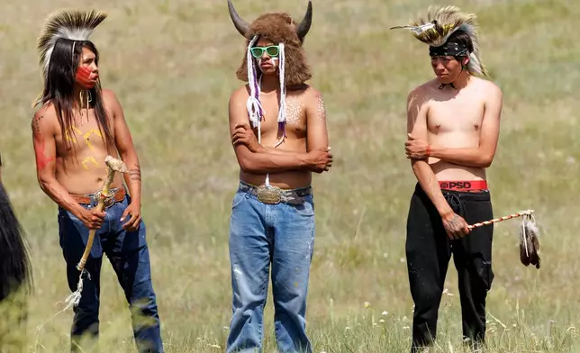 Joseph Fast, 22, Horse Austin Warrior, 19, and John Austin, 18, stand together after the riding in the horse charging event during festivities to commemorate the 150th anniversary of the Battle of the Little Bighorn in Crow Agency, Mont., on Thursday, June 25, 2026. (AP Photo/Tailyr Irvine)