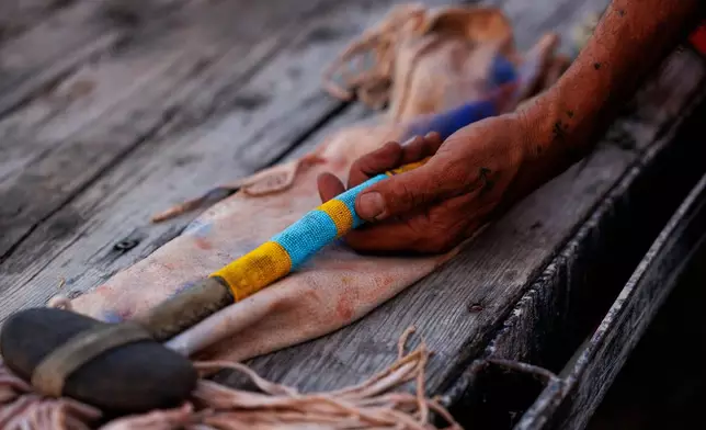 Terry Richard holds the war club that belonged to his grandfather, High Wolf, during festivities to commemorate the 150th anniversary of the Battle of the Little Bighorn, Wednesday, June 24, 2026, in Crow Agency, Mont. (AP Photo/Tailyr Irvine)
