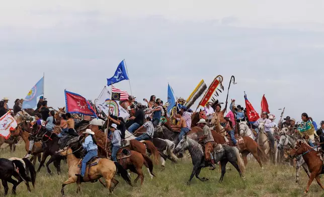 Riders circle the elders representing each tribe present for the horse charging during festivities to commemorate the 150th anniversary of the Battle of the Little Bighorn in Crow Agency, Mont., on Thursday, June 25, 2026. (AP Photo/Tailyr Irvine)