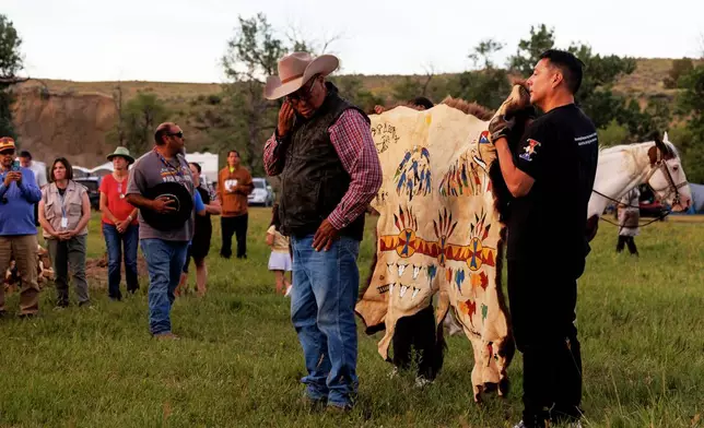 A painted buffalo hide is presented to the Real Bird family during festivities to commemorate the 150th anniversary of the Battle of the Little Bighorn, Wednesday, June 24, 2026, in Crow Agency, Mont. (AP Photo/Tailyr Irvine)