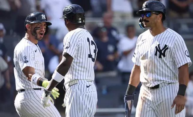 New York Yankees players, from left, José Caballero, Jazz Chisholm Jr. and Trent Grisham react after Chisholm Jr. hit a three run home run in the eighth inning of a baseball game against the Boston Red Sox, Sunday, June 7, 2026, in New York. (AP Photo/Pamela Smith)
