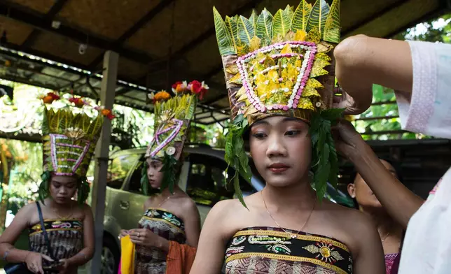 Ketut Alit Widiantary prepares to perform the sacred Rejang dance during Kuningan holiday, which marks the end of the 10-day Galungan festival celebrating the victory of good over evil, in Karangasem, Bali, Indonesia, Saturday, June 27, 2026. (AP Photo/Firdia Lisnawati)