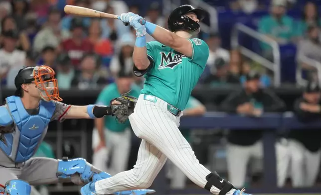 Miami Marlins' Kyle Stowers, right, hits a home run during the second inning of a baseball game against the San Francisco Giants, Sunday, June 21, 2026, in Miami. (AP Photo/Jim Rassol)