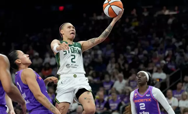 Seattle Storm guard Natisha Hiedeman (2) drives past Phoenix Mercury forward Noemie Brochant (1) and Mercury forward Kahleah Copper (2) to score during the first half of a WNBA basketball game, Saturday, June 20, 2026, in Phoenix. (AP Photo/Ross D. Franklin)